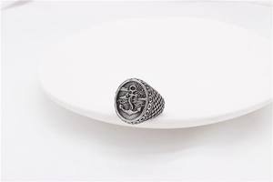 Detailed macro shot of vintage stainless steel anchor ring with nautical sun and wave motifs