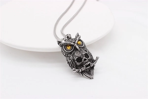 Detailed view of Gothic owl skull pendant with orange gemstones on a ball chain