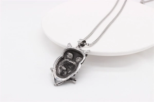 Macro shot of owl skull pendant with vintage oxidation on a box chain for men
