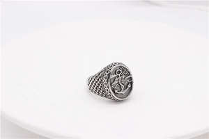 Close-up of vintage anchor ring with detailed nautical carvings and distressed silver finish