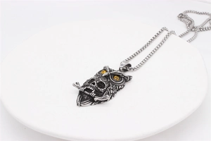 Detail view of gothic owl skull pendant with yellow gems and vintage steel finish