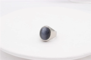 Vue détaillée d'une bague argentée avec une pierre ovale gris foncé à effet œil de chat