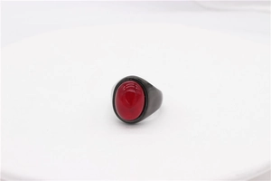 Détail macro d'une pierre rouge ovale sertie dans une bague vintage en métal noir