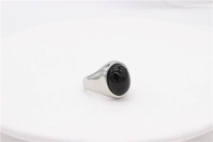 Vue macro d'une bague ovale en agate noire argentée sur un support en pierre