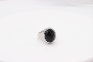 Gros plan sur bague en argent ornée d'une grande pierre d'onyx noire taillée sur fond blanc