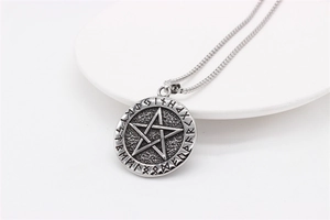 Macro view of vintage Nordic Viking pendant with pentagram and runic engravings on box chain