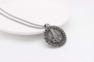Macro view of vintage Viking Mjölnir pendant with Nordic rune circle engraving