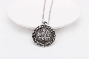 Detailed macro view of vintage Viking Mjölnir pendant with runes on a snake chain
