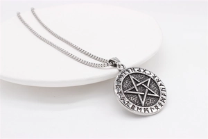 Macro shot of Viking rune pendant with star design on textured stainless steel surface