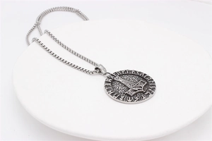Macro detail of Nordic Viking Mjölnir pendant with runes on stainless steel chain