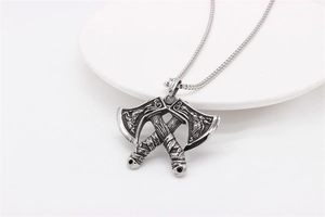 Macro shot of Viking double battle axe pendant with intricate dragon engravings in steel