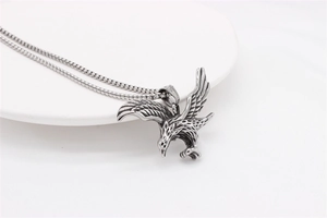 Detailed view of retro silver eagle pendant with intricate wing feathers on steel chain