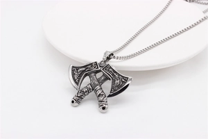 Close-up of vintage Viking double axe pendant with intricate dragon engravings in silver
