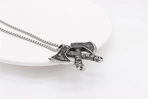 Macro shot of Viking double axe pendant with detailed totem engravings and silver finish