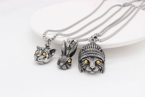 Detail of vintage silver rabbit and owl pendants with gold accents on steel chains