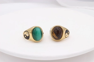 Macro detail of vintage gold rings with green cat's eye and tiger eye yin yang relief