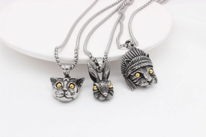 Detailed view of vintage rabbit and feline pendants with antique silver finish on white tray