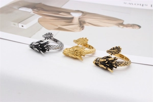 Detail of dragon rings in silver and gold showing intricate scale textures and open design