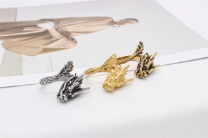 Detail view of dragon rings in silver and gold with intricate vintage scale carvings