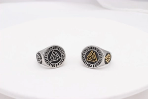 Macro detail of Viking Valknut rings in silver and gold with Nordic Rune engravings