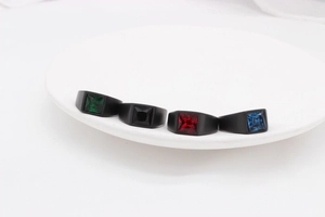 Lot de quatre bagues noires mates avec pierres précieuses carrées : émeraude, onyx et rubis