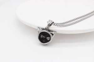 Macro shot of silver rabbit pendant with vintage finish and delicate chain on white background