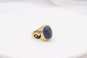 Macro detail of gold titanium ring showing blue lapis lazuli and yin yang engraving