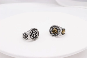 Viking Valknut rings with Celtic runes on a white pedestal in a professional studio setting