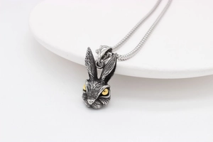 Detailed macro view of a vintage rabbit pendant with intricate fur texture and golden eyes