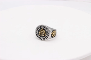 Detailed close-up of Viking Valknut ring with golden runes on vintage steel surface