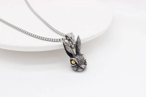 Detailed close-up of retro rabbit head pendant with silver texture and golden eyes