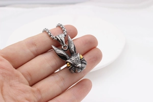 Detail of vintage silver rabbit pendant with gold eyes and textured fur on ring chain