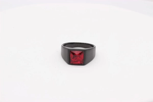 Détail d'une bague en acier noir mat avec une pierre précieuse rouge carrée