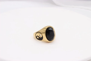 Detail of vintage gold ring with large oval black agate and yin yang side motif