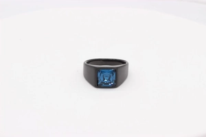 Détail d'une bague en acier titane noir mat avec une pierre bleue carrée incrustée
