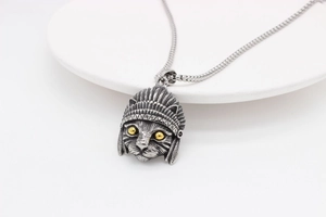 Detailed view of vintage silver cat pendant with feather headdress and yellow eyes