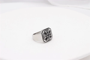 Macro detail of vintage men's stainless steel signet ring with black iron cross motif