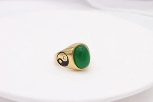 Detailed macro view of vintage gold ring with oval green stone and yin-yang symbols