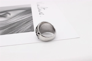 Detail of silver stainless steel band ring featuring black cross engravings on side