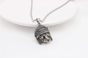 Detail of vintage silver cat pendant with Indian feather headdress and yellow eyes