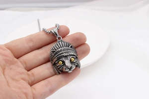 Detailed macro view of vintage titanium steel necklace pendant featuring a feathered cat head