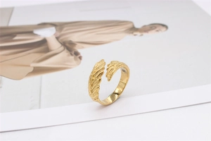 Macro detail of vintage gold feather ring showing intricate wing texture and open design