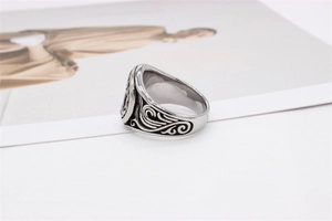 Close-up of vintage silver titanium steel ring with intricate floral carvings and aged finish