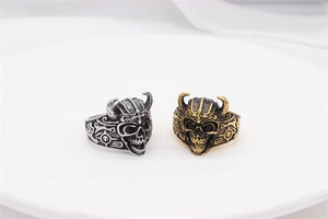 Detail shot of vintage skull rings with horns in silver and gold polished finishes