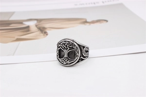 Close-up of vintage tree of life relief and scrollwork on men's stainless steel ring