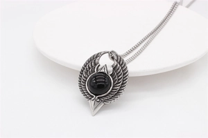 Macro shot of gothic eagle wings pendant with black onyx stone inlay and steel chain