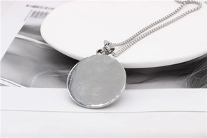 Détail du pendentif rond en acier argenté avec chaîne à mailles carrées pour hommes
