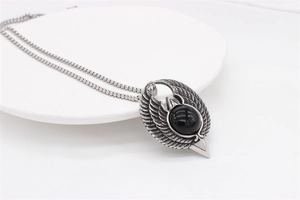 Detailed view of vintage eagle wings pendant with black bead on stainless steel chain