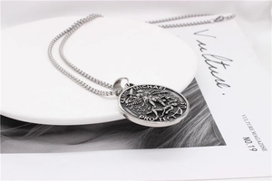 Détail du relief de l'Archange Saint Michel sur un pendentif en acier inoxydable