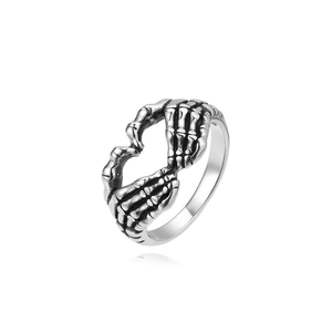 Detailed view of vintage silver skull hand heart ring with gothic oxidized finish